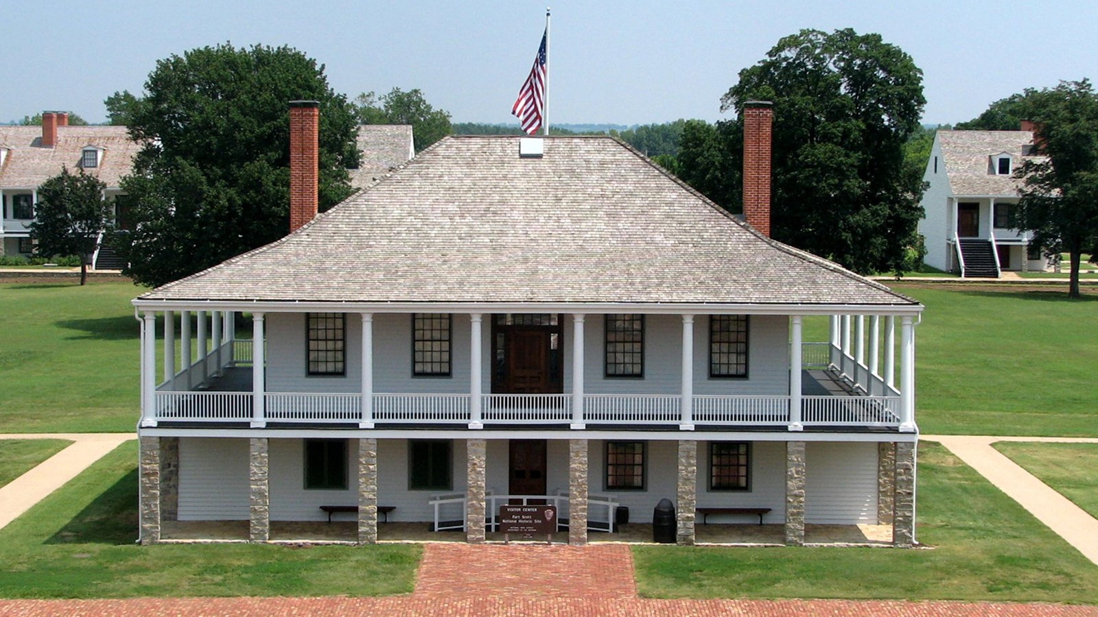 two story building with bricks in front and flag pole behind. 