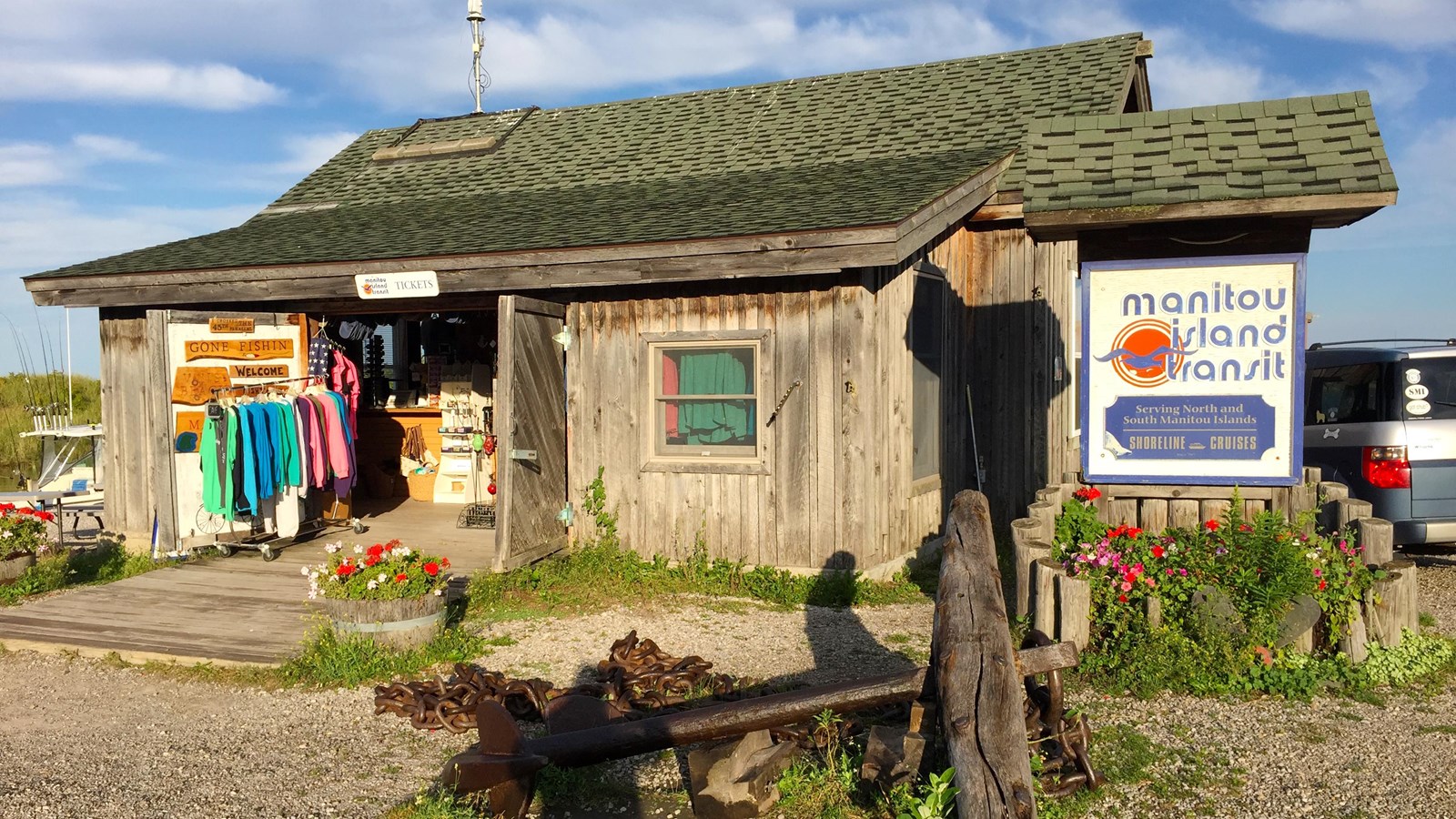 Historic shanty building with open doors showing brightly colored tshirts and merchandise