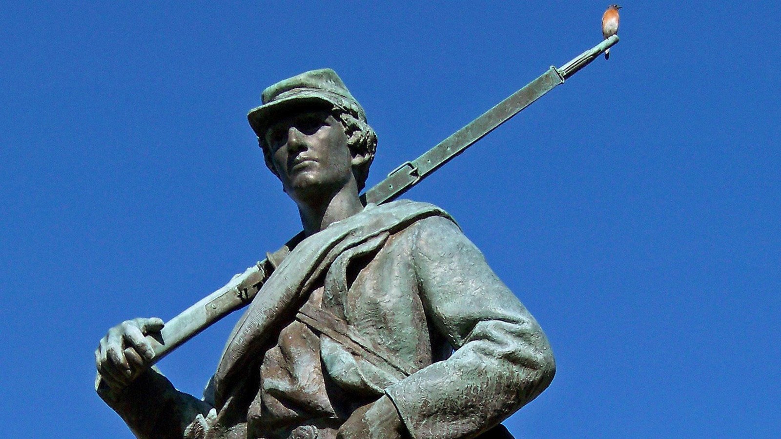 A single bronze statue of a soldier holding his musket over his right shoulder.