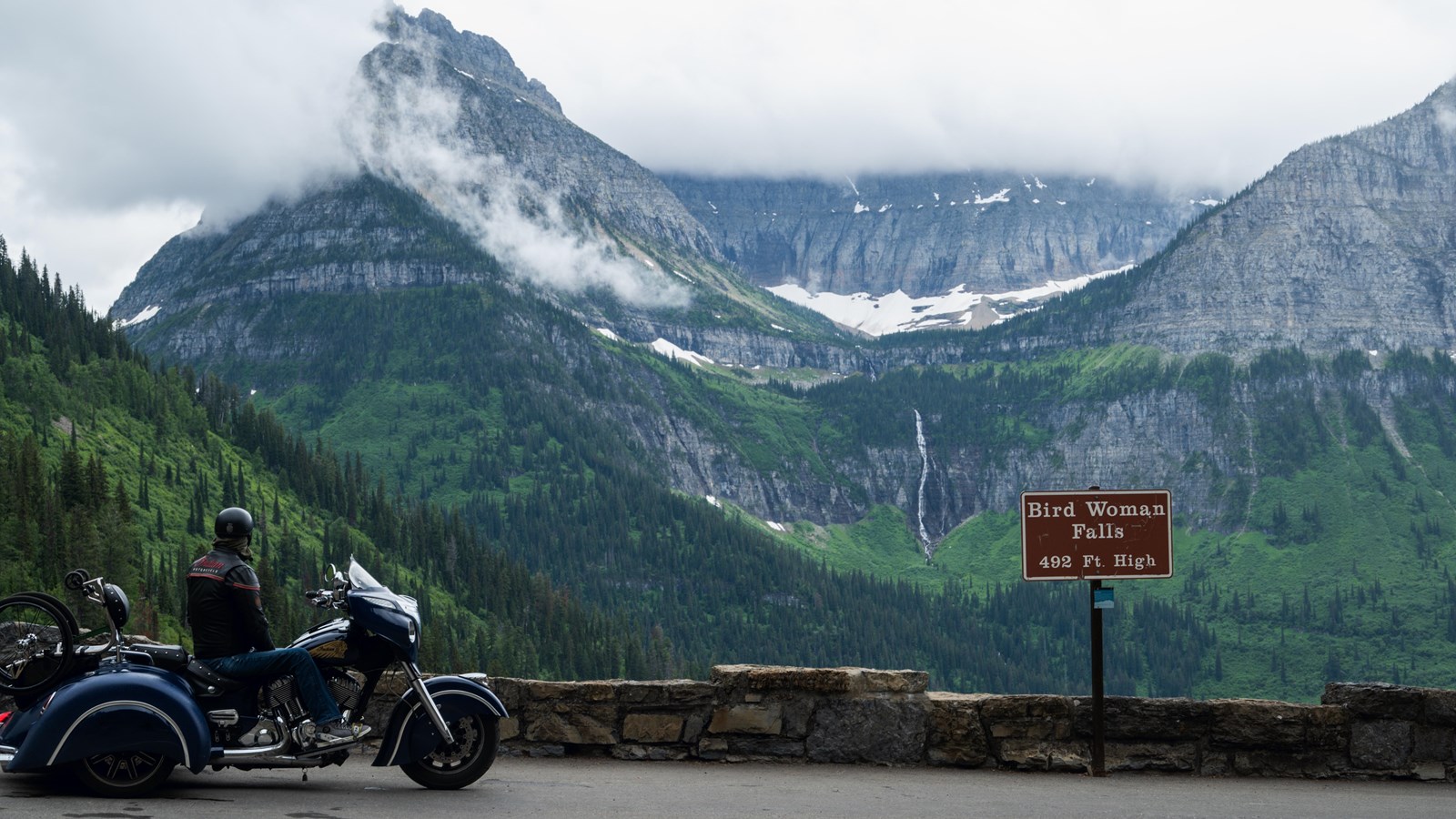 A motorcyclist marvels at the view from Bird Woman Falls Overlook