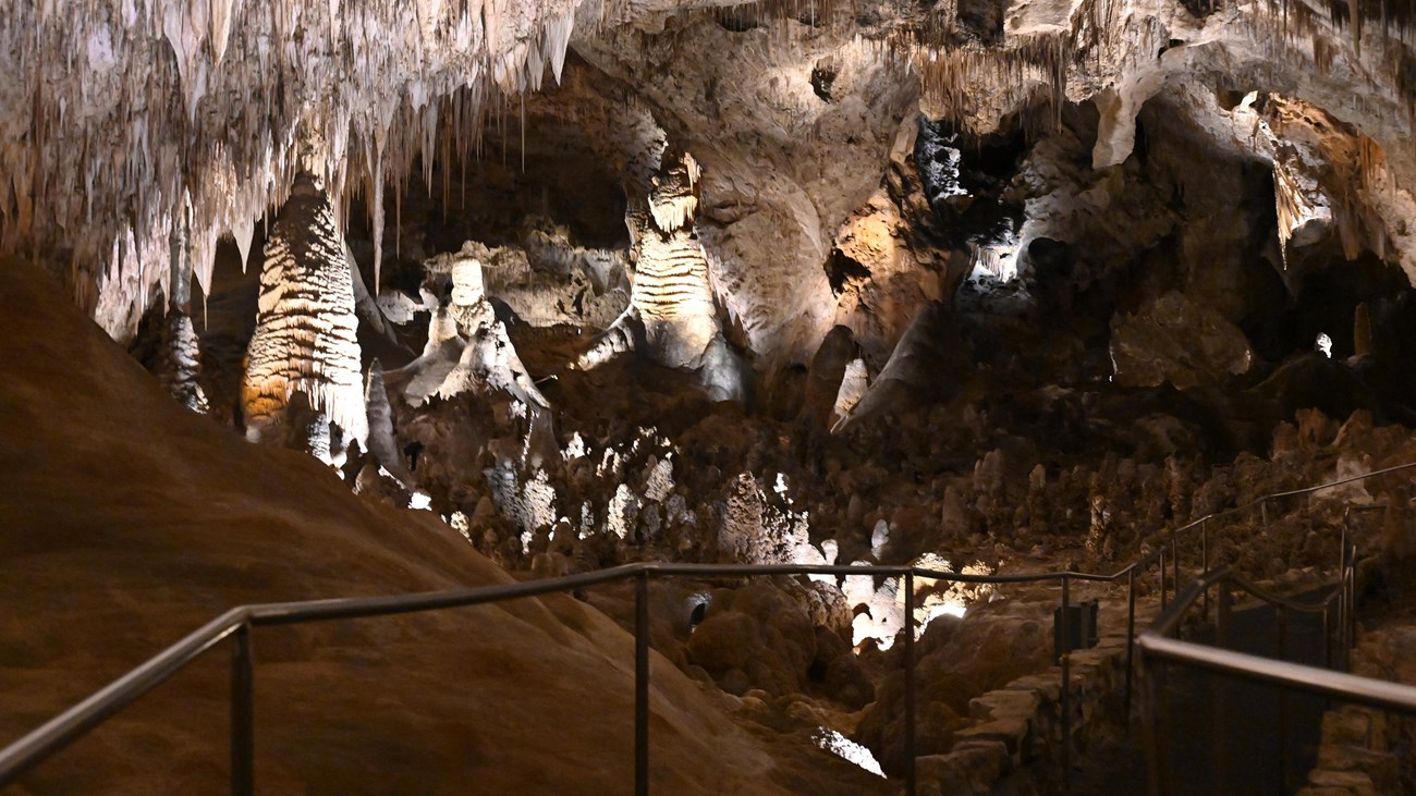 Photo of the Big Room with cave formations and the trail.