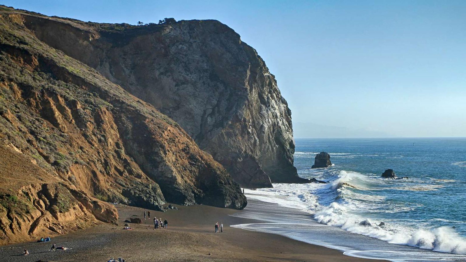 View of the cove, with the rocky cliffs encircling the crashing waves.