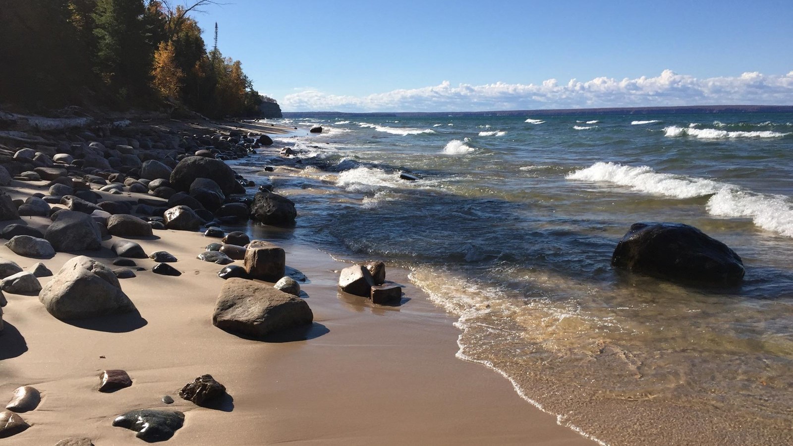 small and medium sized boulders and rocks on the beach and in the water.