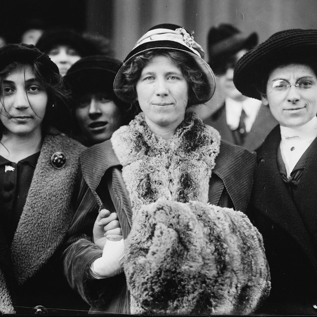 Three women standing side by side, looking at the camera, courtesy Library of Congress. 