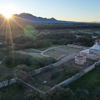 aerial photo of mission grounds with sunrise over mountains in the distance