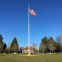 The American flag flies on the Parade Ground flagstaff on a sunny day.