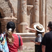 ranger pointing to front of church, visitors listening