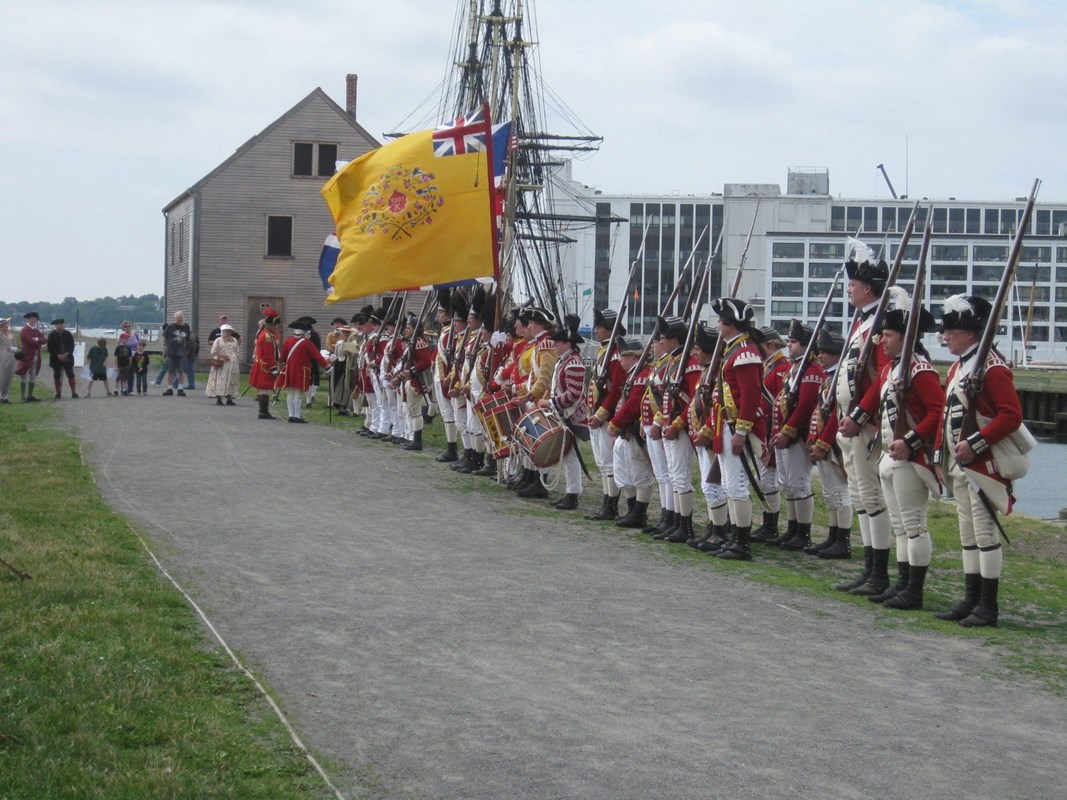 A line of historic reenactors dressed in British 