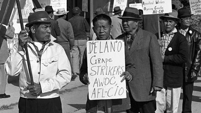Filipino workers on strike hold up protest signs.