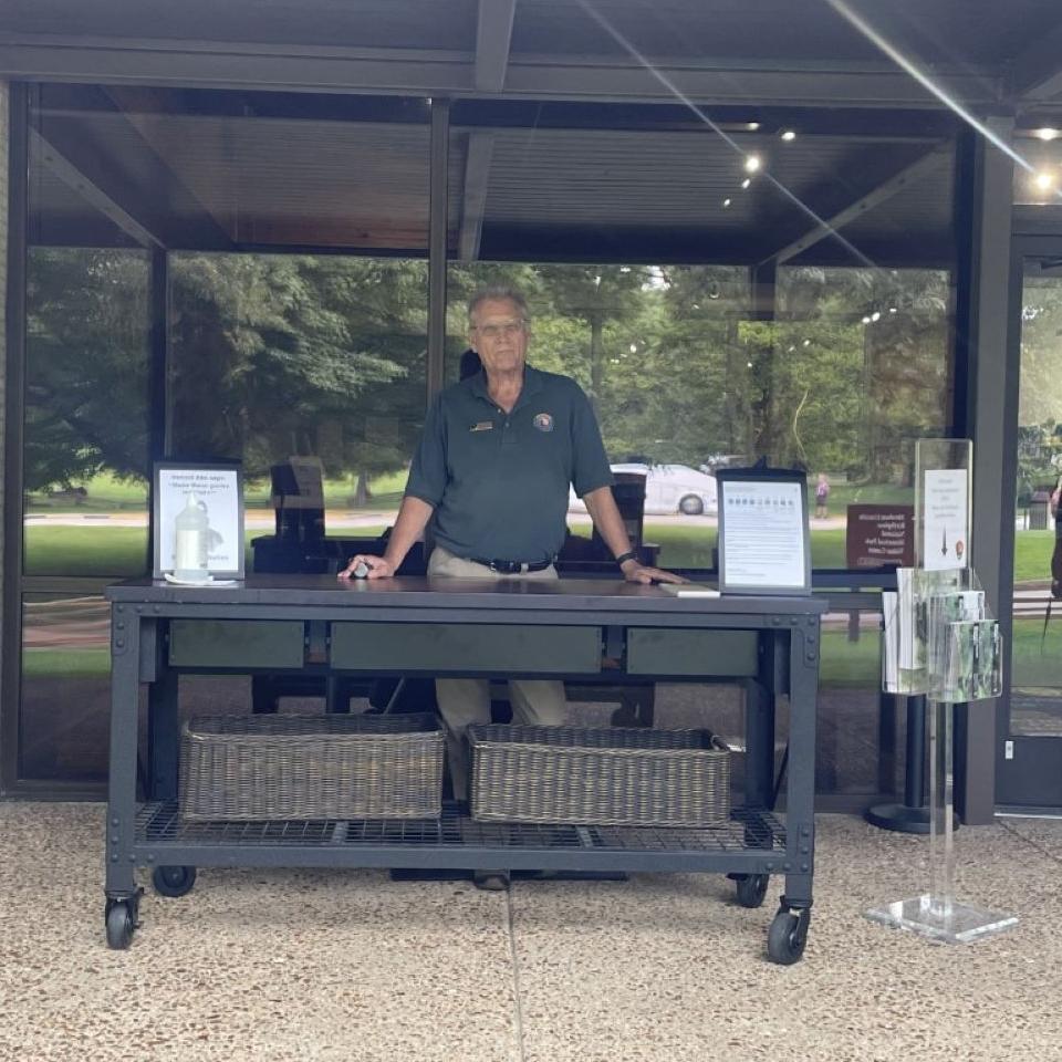 a volunteer standing at an information desk