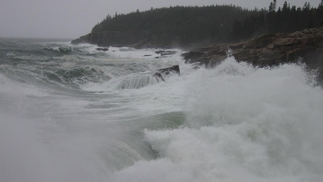 strong waves crash against the rocks during a storm