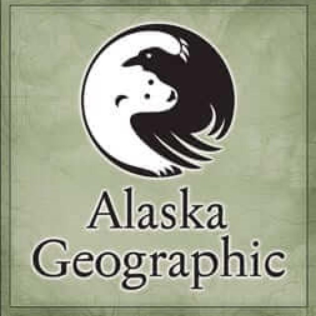 the alaska geographic logo with a black raven and white polar bear wrapped together in a circle.