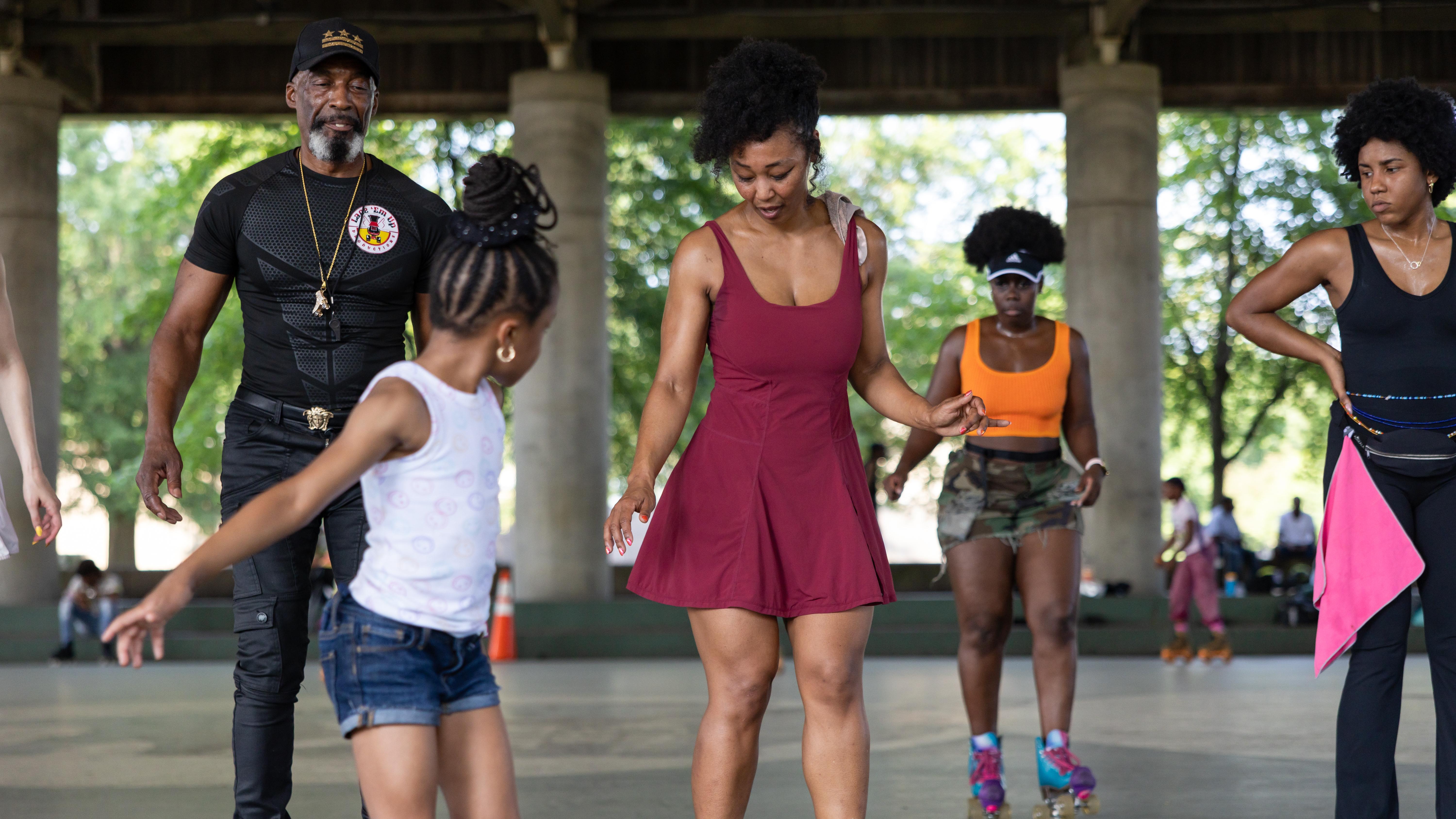 Kenneth "Rollo" Davis, left, shows off his moves as he dances to music played by DJs
