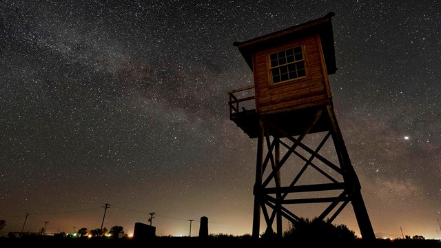 An old guard tower against a starry night sky