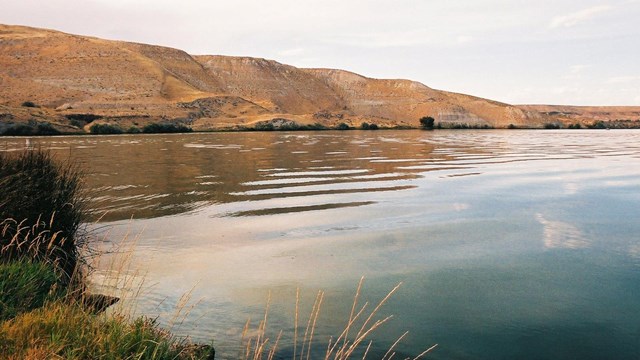 A view of golden rocky hills from across the Snake River.