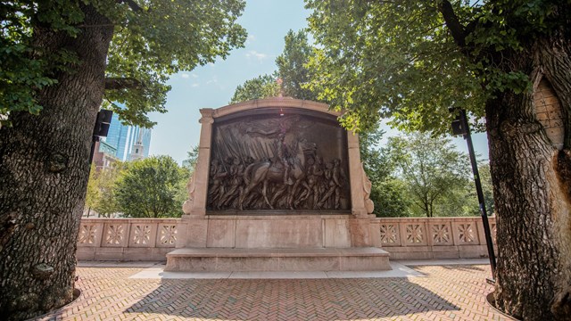 The 54th Regiment Monument is surrounded by leafy trees