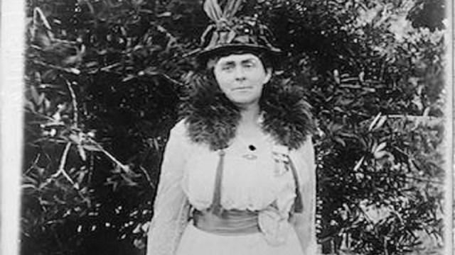 Black and white photo of woman in white dress and hat