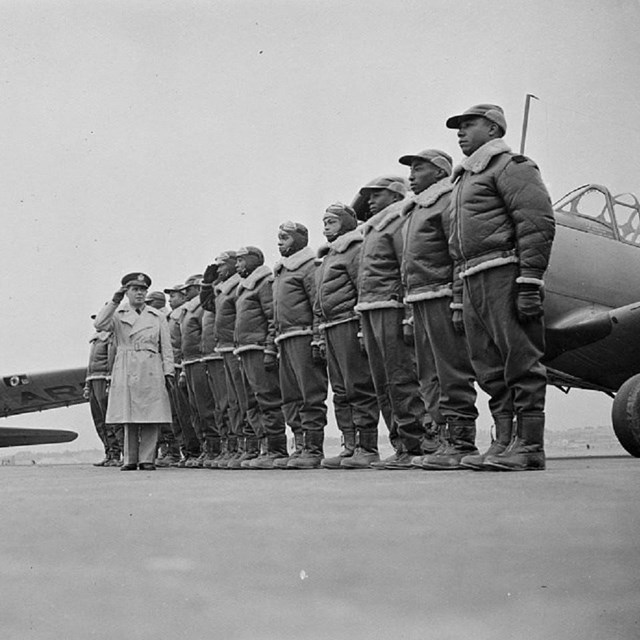 African American service men in uniform in front of planes