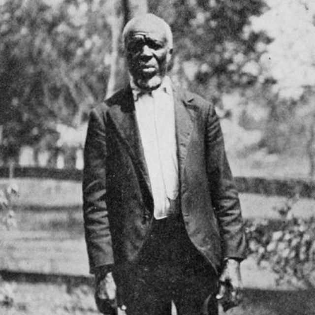 African American man wearing blazer and holding hat