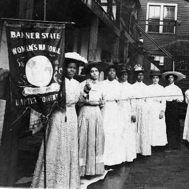 A group of African American women with a banner