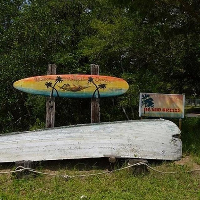 Overturned boat and colorful sign