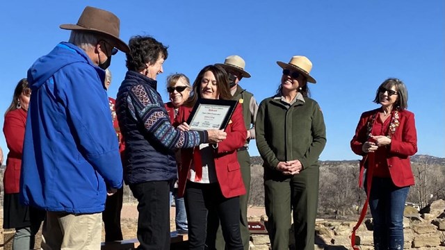 A Chaco Culture Conservancy board member holds a framed certificate.