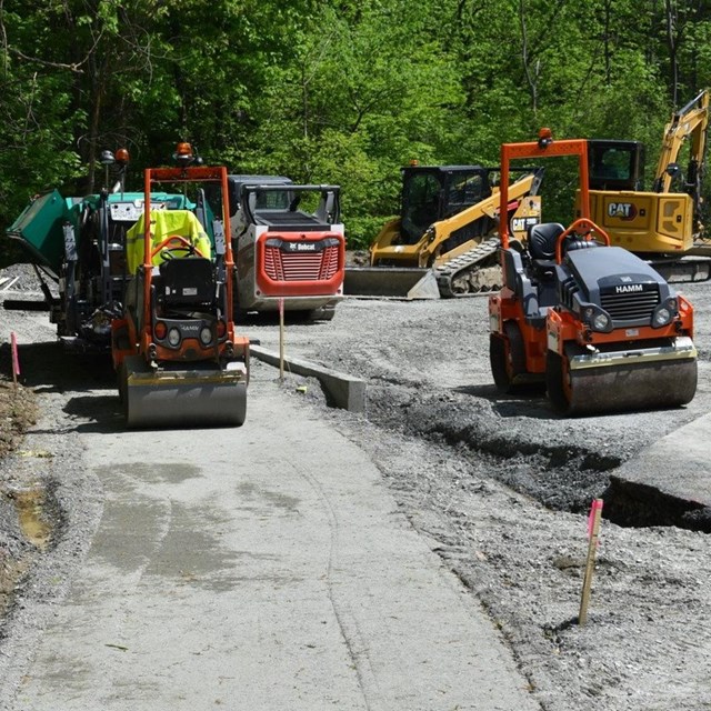 Construction equipment and vehicles working on a road.