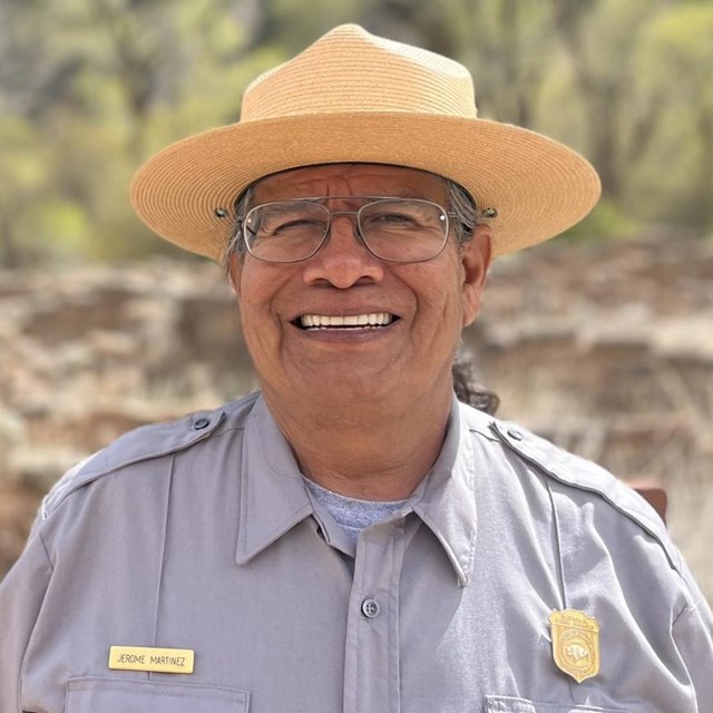 A picture of a smiling man in a park ranger uniform.