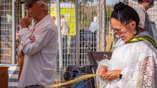 A Seminole woman makes braided baskets at a local festival
