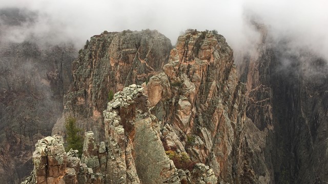 Low clouds hanging near the tops of canyon walls and formations