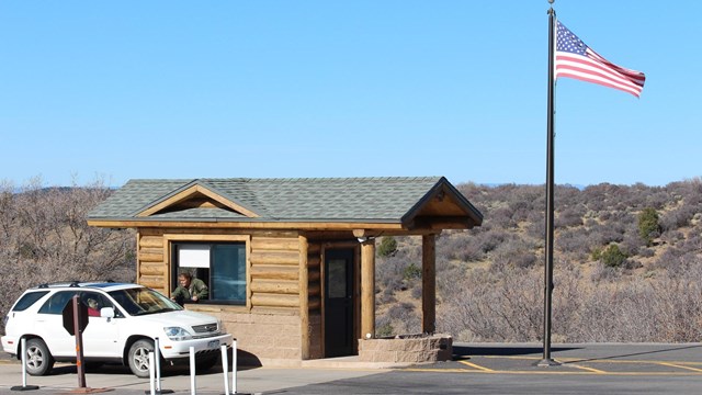 A white vehicle stops at a small entrance booth at Black Canyon.