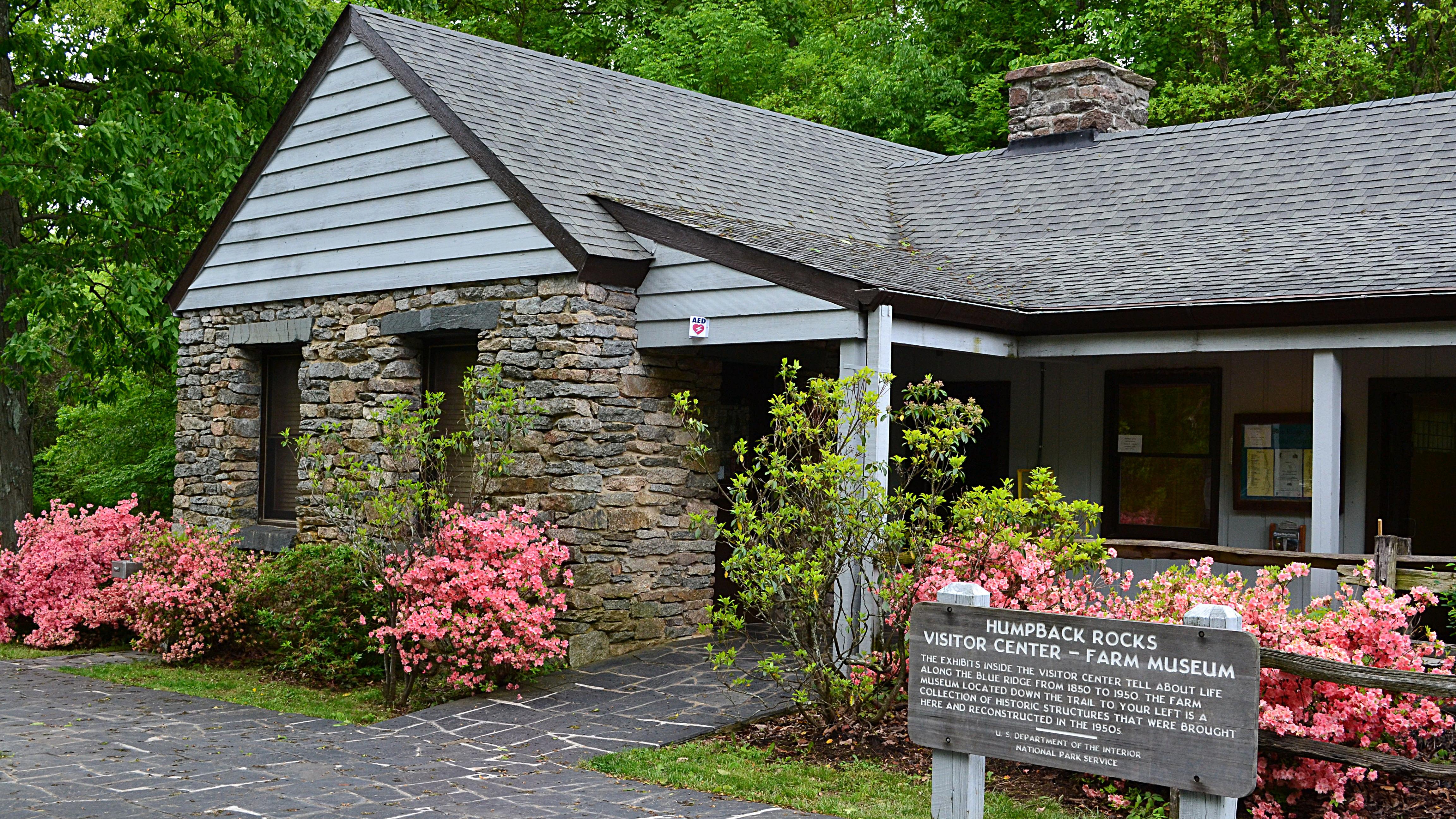 Humpback Rocks Visitor Center, a small, classic national park style building, with azaleas blooming.