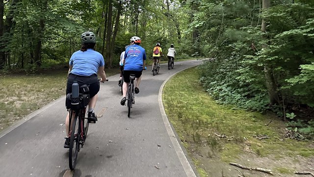 Bikers riding down paved path