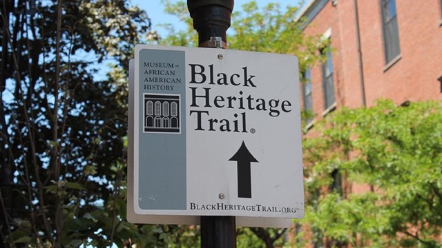 black heritage trail sign attached to lightpost