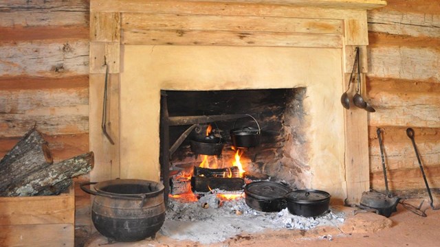 An open fire inside a rustic cabin.
