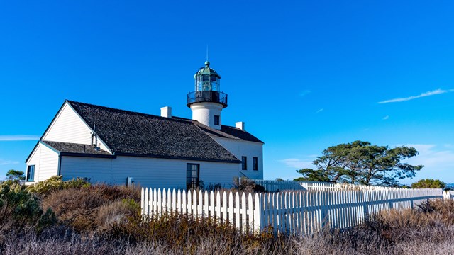 A photo of a lighthouse building in natural surroundings. 