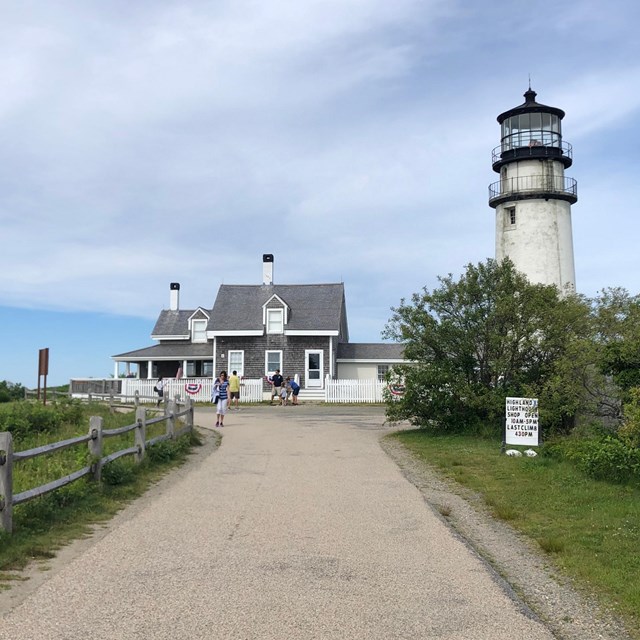 A driveway leads up to a house with a lighthouse next to it.