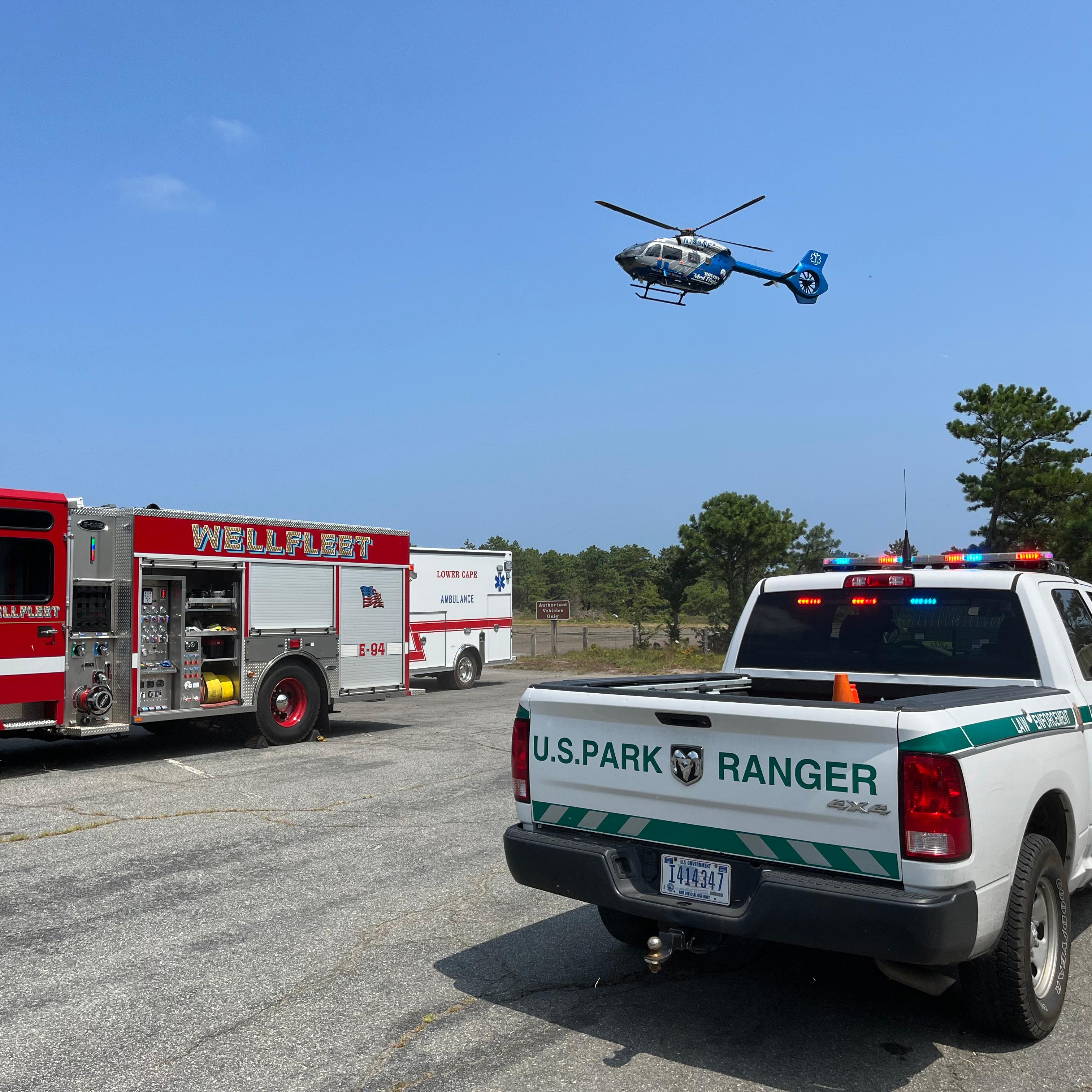 Fire truck, NPS truck, and helicopter in the air.
