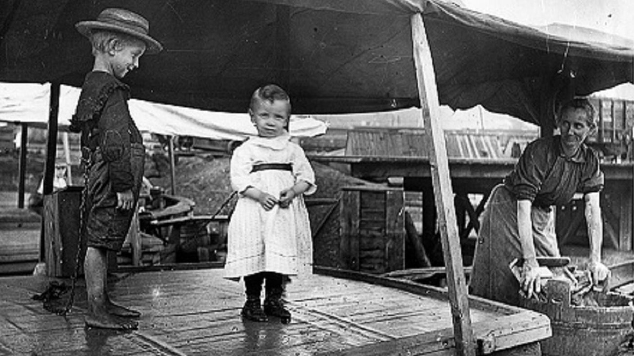 Two small children tied to the cabin of a canal boat as a precaution.