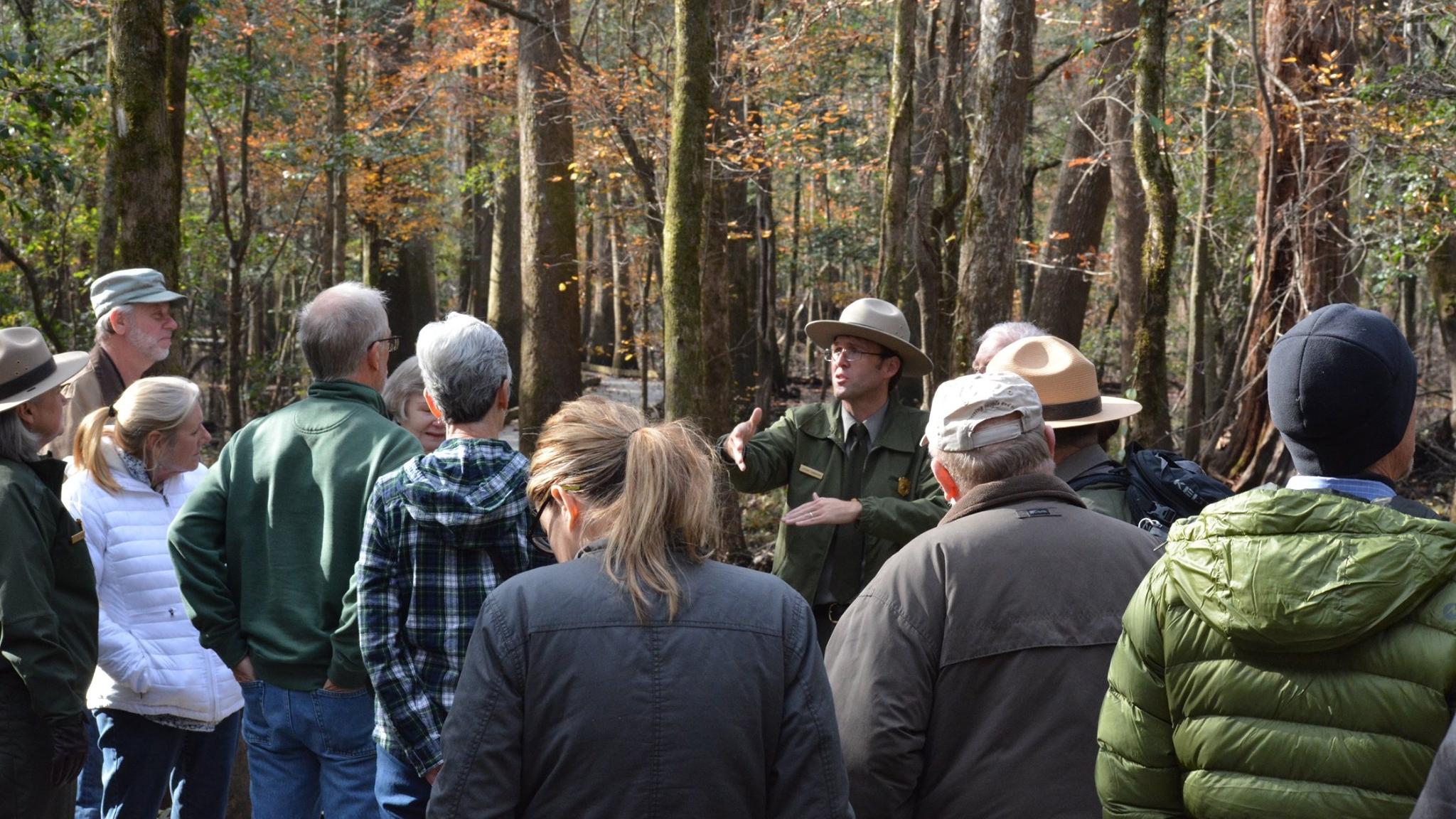 A ranger provides information to visitors outdoors 