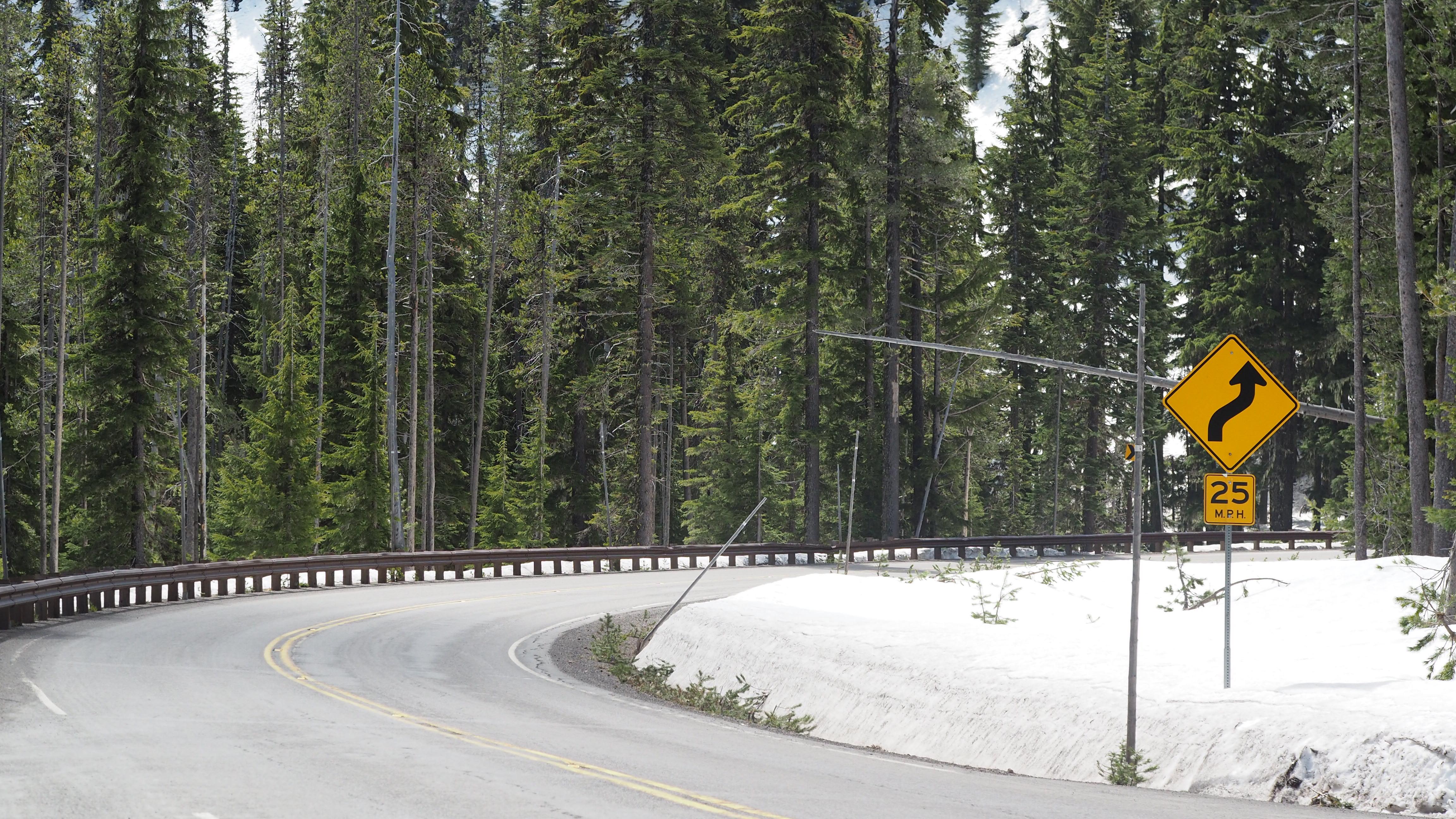  a guard rail on the left curves with OR Hwy 62, on the right is a slow 25 mph sign 