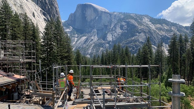 Construction workers on a platform with mountains in the distance