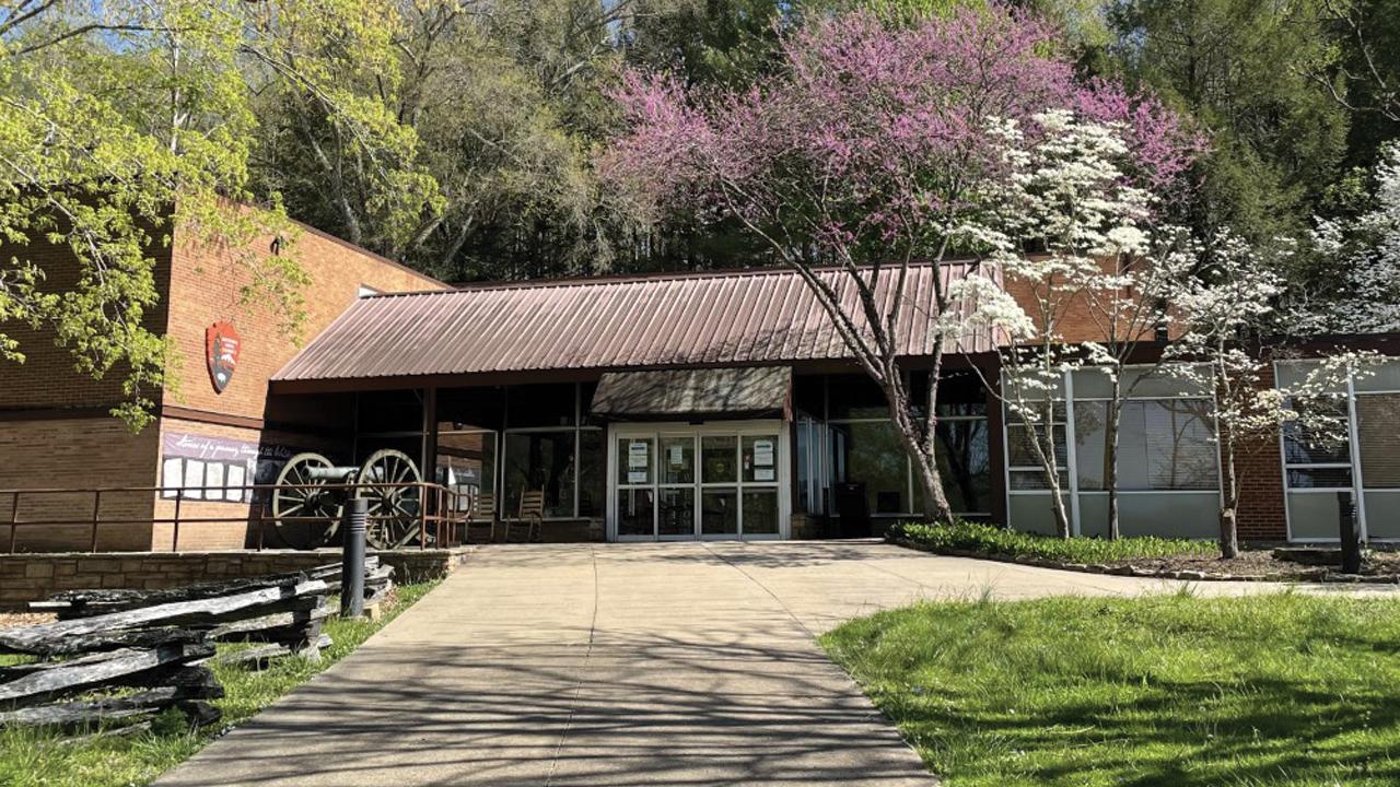 modern building with glass windows surrounded by trees.