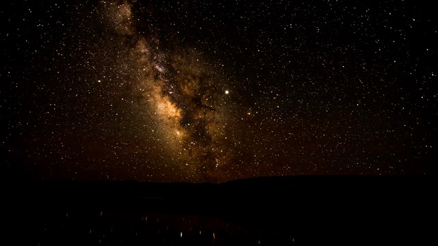 Photo of the night sky and Milky Way reflected over water