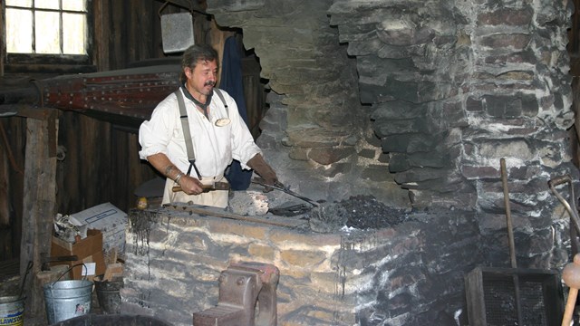 Blacksmith at work at the furnace