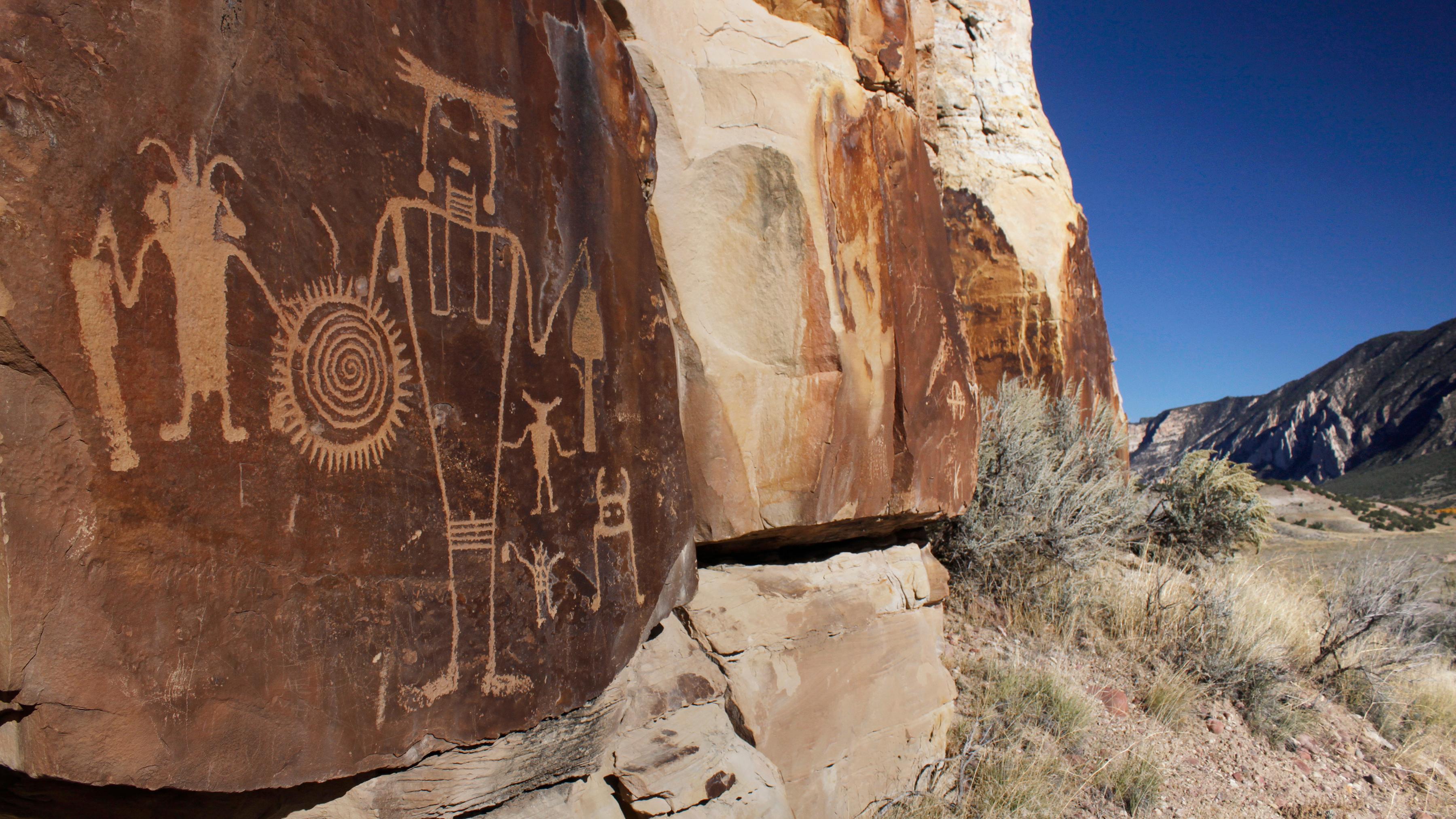 Orange colored rock with Native American designs chiseled into rock