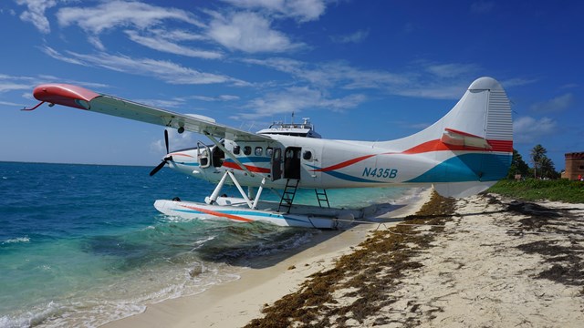 A seaplane resting on sand and water
