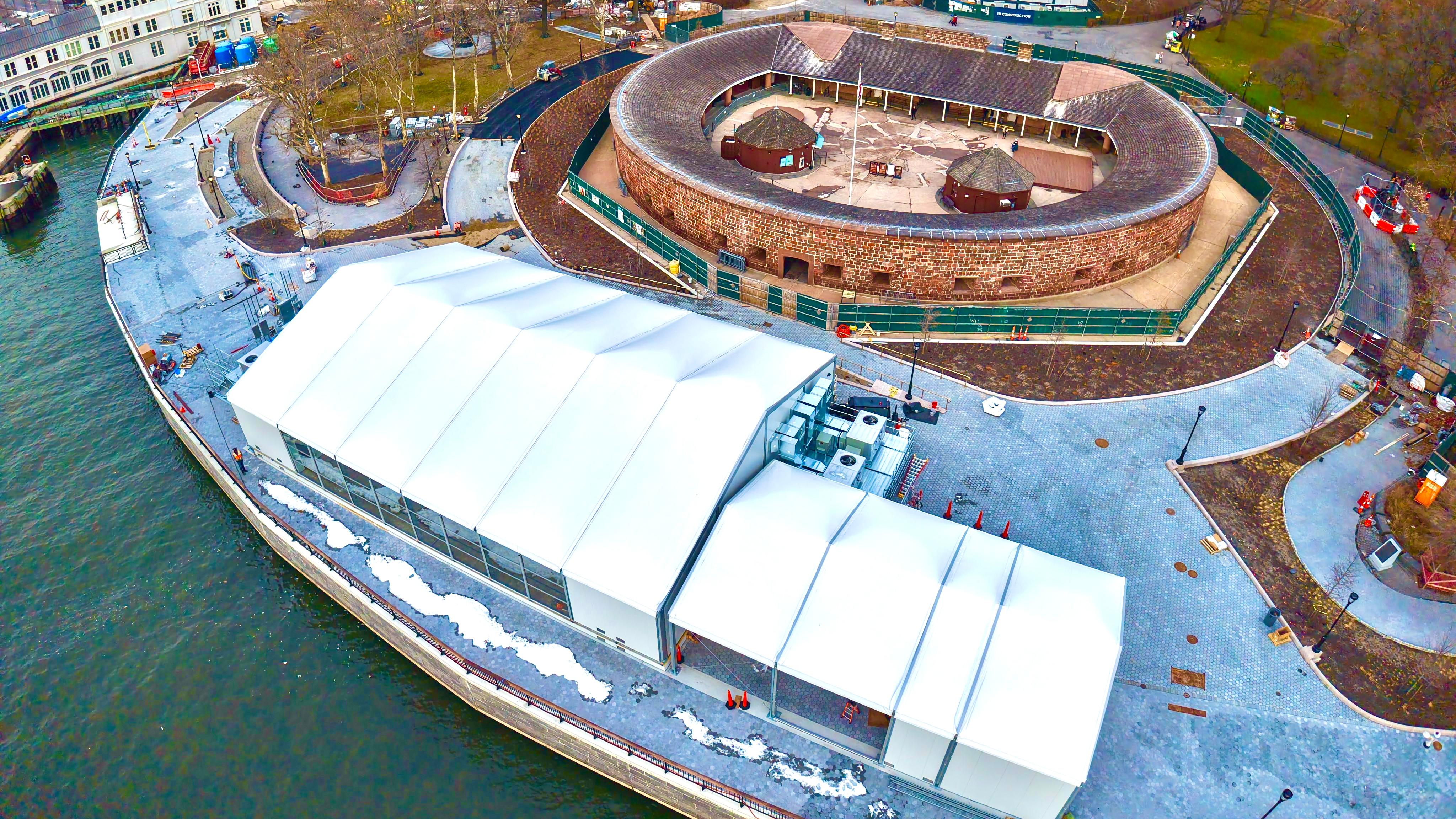 An aerial view of the white security building next to an oval structure.