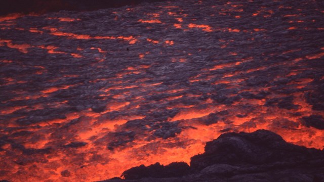 Molten red lava flowing in an active eruption