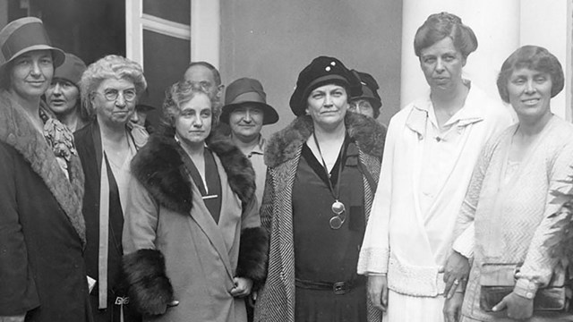 A group of women standing near a building.